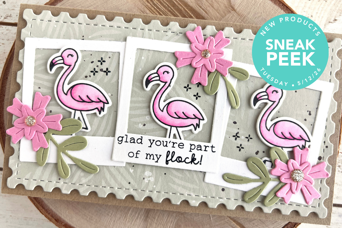 Handmade greeting card with three pink flamingos among white photo frames, pink flowers, and green leaves on a gray patterned panel; sentiment: "glad you're part of my flock!"