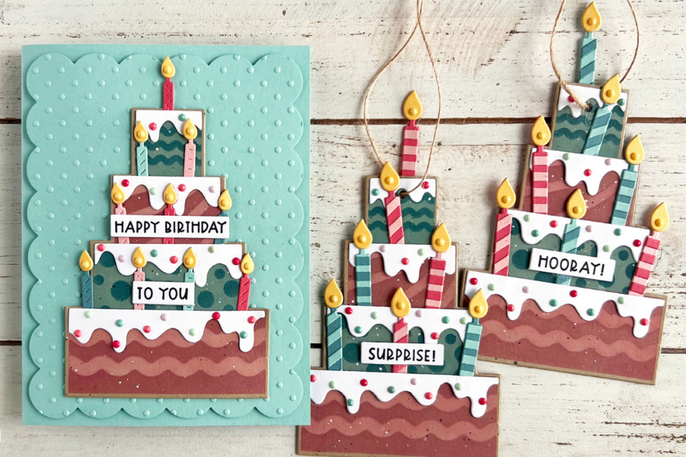 Crafty turquoise birthday card with a layered multi-tier cake and lit candles, saying 'Happy Birthday' and 'To You'.