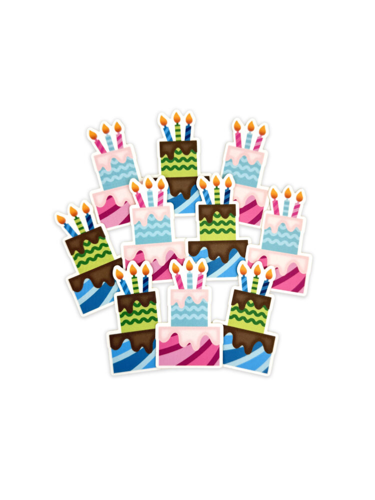 Pile of colorful cartoon birthday cakes with lit candles on a white background